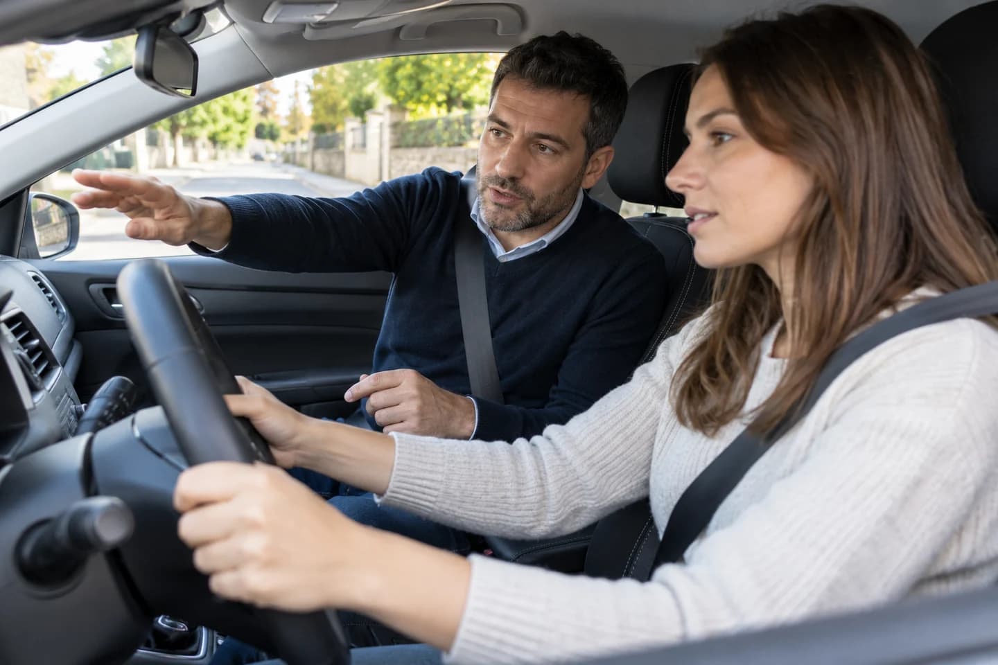 Un moniteur explique une leçon dans une voiture à l’arrêt.